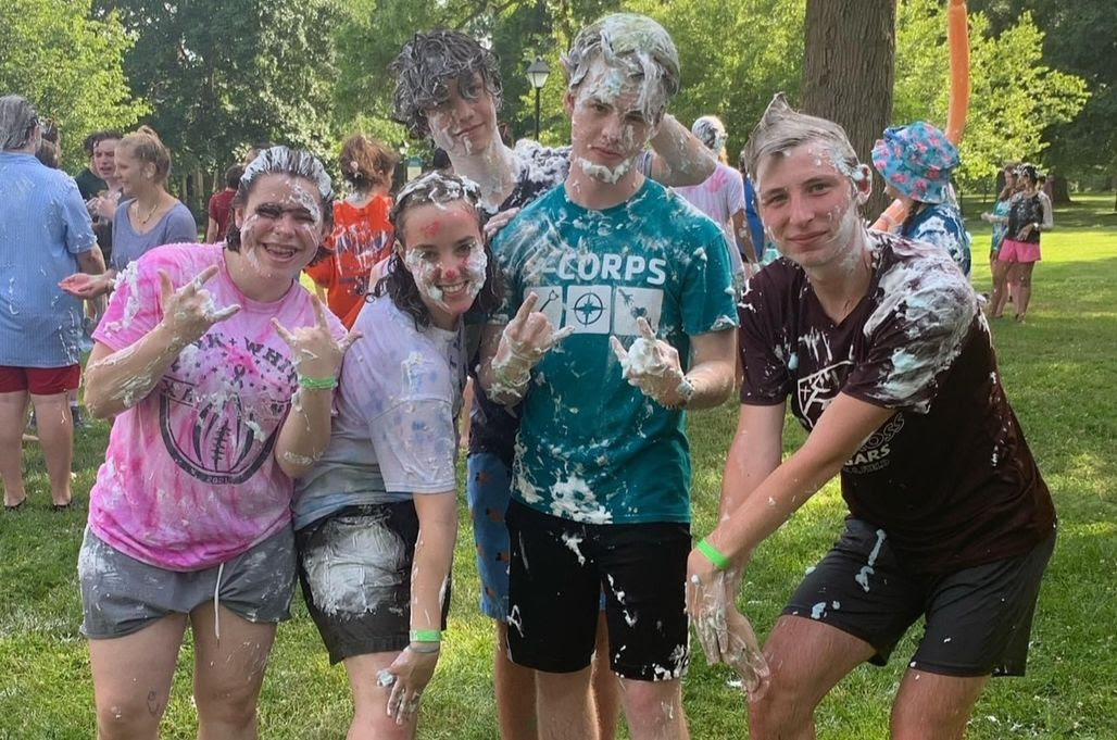 Four kids having a shaving cream fight.